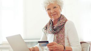 senior woman using her credit card to do banking online